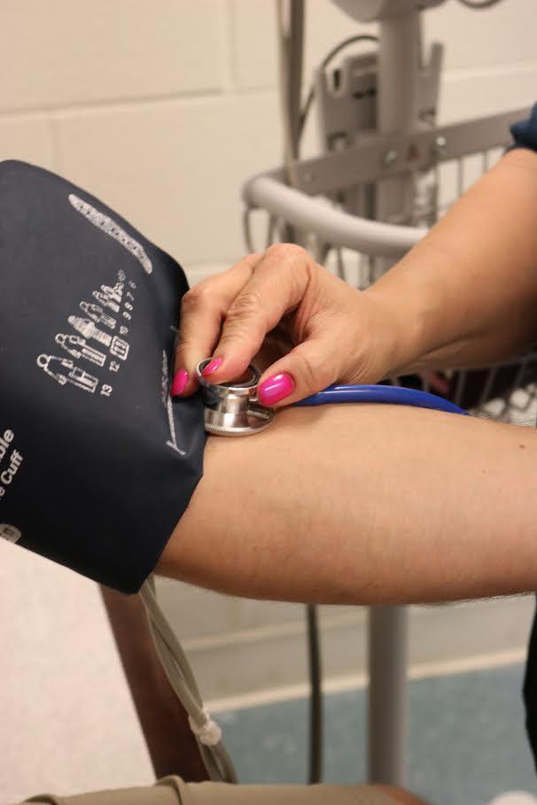 Photograph of a female nurse taking blood pressure of an inmate