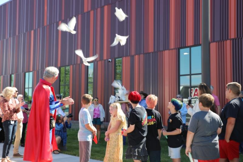 White doves being released around large crowd of people. 