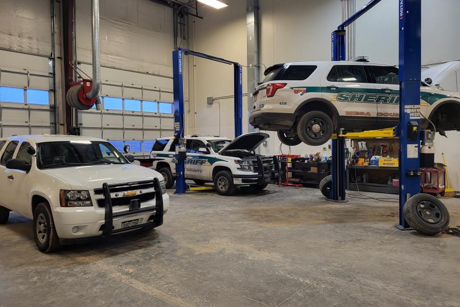 Photograph of Fleet Management Garage Bay with cars being worked on.