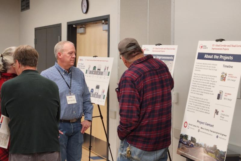 People looking at project board at open house. 