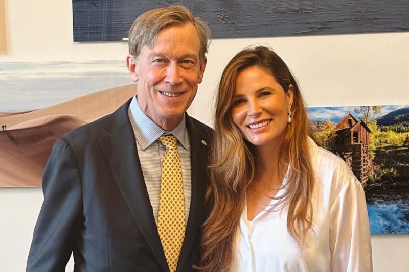 Two individuals standing next to each other smiling. Woman (Mesa County Commissioner Bobbie Daniel) on right and man (U.S. Senator John Hickenlooper) on left. 