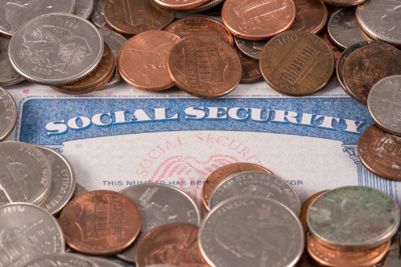 Social Security card surrounded by loose change. 
