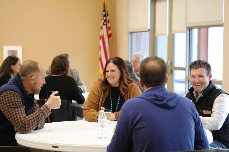 County leaders and members of the public sit at a round table together. 