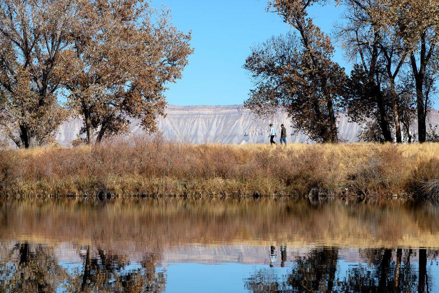 Two people walk along Connected Lakes in Mesa County, CO.