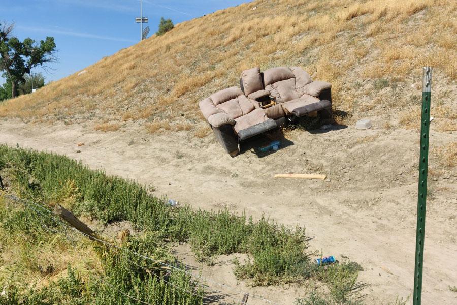 Tan couch sits on open land