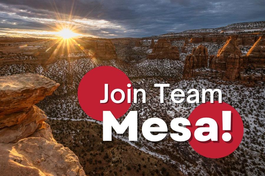 Sunrise over the Colorado National Monument with snow dusted rocks and a white and red element reading, "Join Team Mesa!"