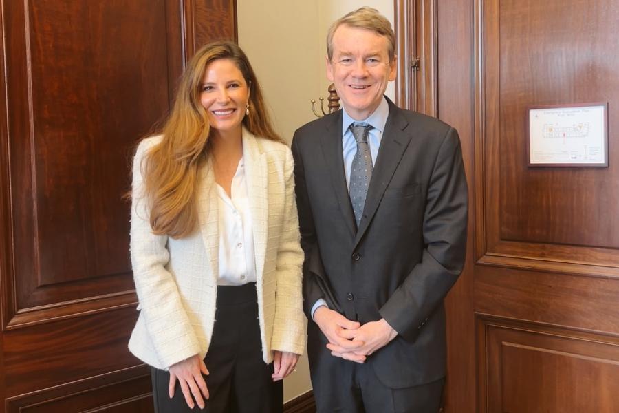 Two individuals standing next to each other smiling. Woman (Mesa County Commissioner Bobbie Daniel) on left and man (U.S. Senator Michael Bennet) on right. 