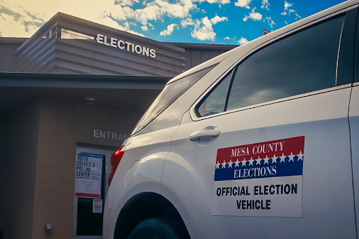 Mesa County elections department building with vehicle in front.